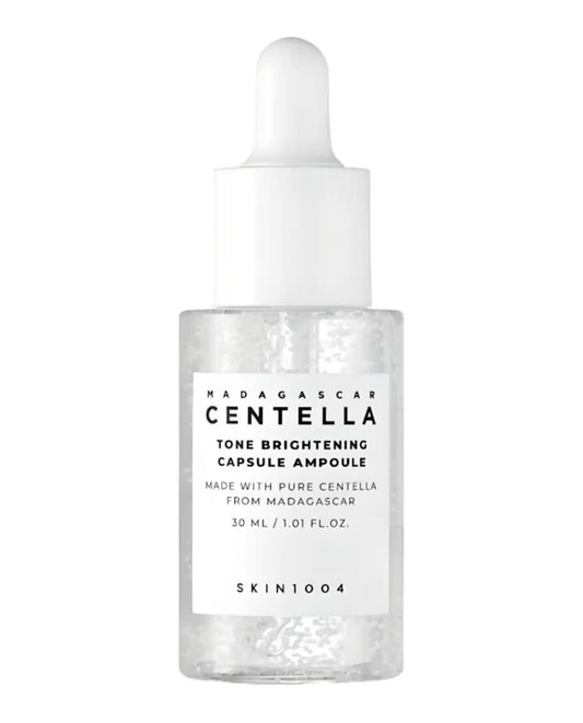 Ampolla facial iluminadora con centella asiática de SKIN1004, en un frasco transparente con gotero blanco.